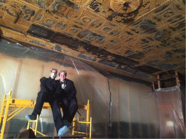 Hands on crew members inside the Sunshine building doing restoration work to the punched tin ceiling. Photo courtesy of Alex Thomas.