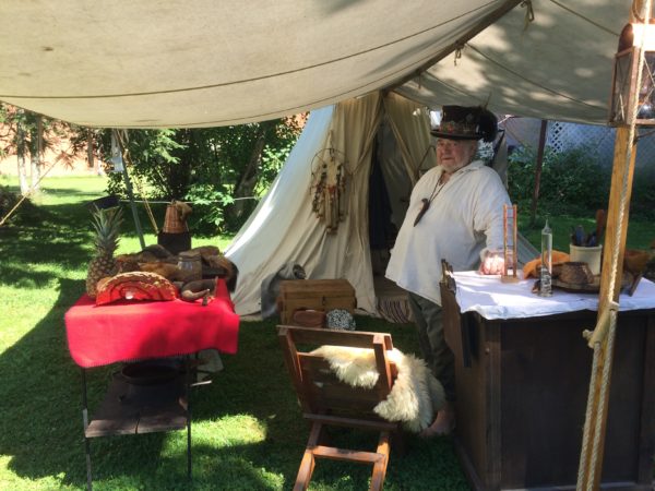 Joe at his tent surrounded by possessions that a trapper would have had access to, but might not have always owned