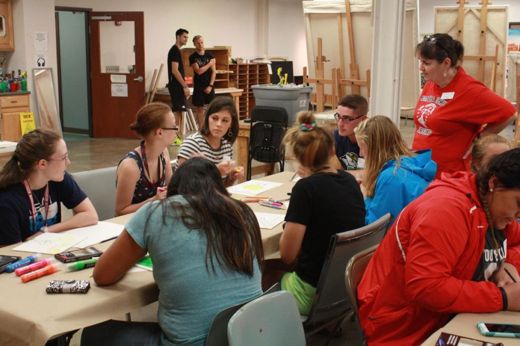 Photo Caption: Karen Seel, standing right, assistant professor of nursing at Davis & Elkins College, leads new students in an art project as part of the “Write Your Story” initiative. Students were asked to create a work that describes their virtues.